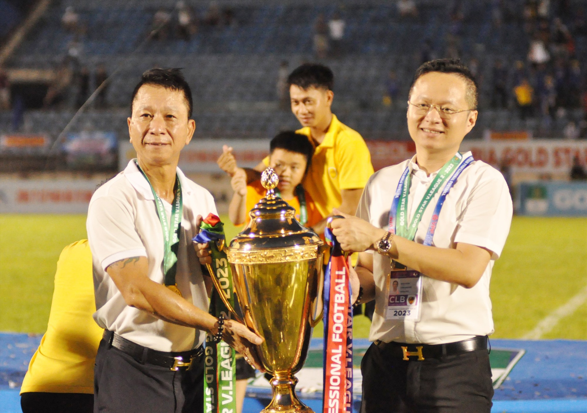 HLV Văn Sỹ Sơn (bên trái) nâng cao chiếc cúp vô địch. Ảnh: A.S