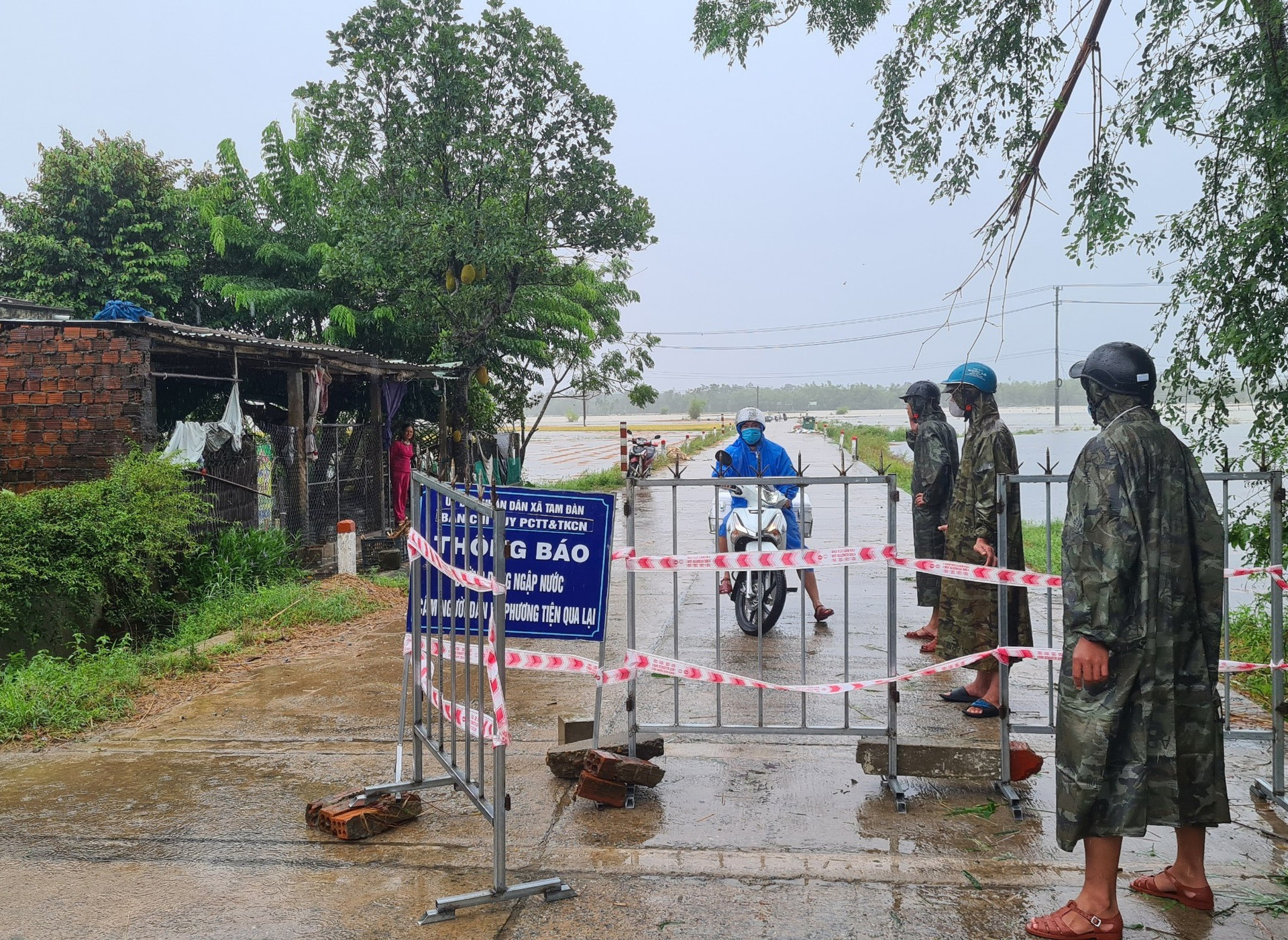 Lực lượng chức năng huyện Phú Ninh thực hiện chốt chặn tại các điểm xung yếu và hướng dẫn người dân đi lại để đảm bảo an toàn trong mùa mưa bão. Ảnh: P.V
