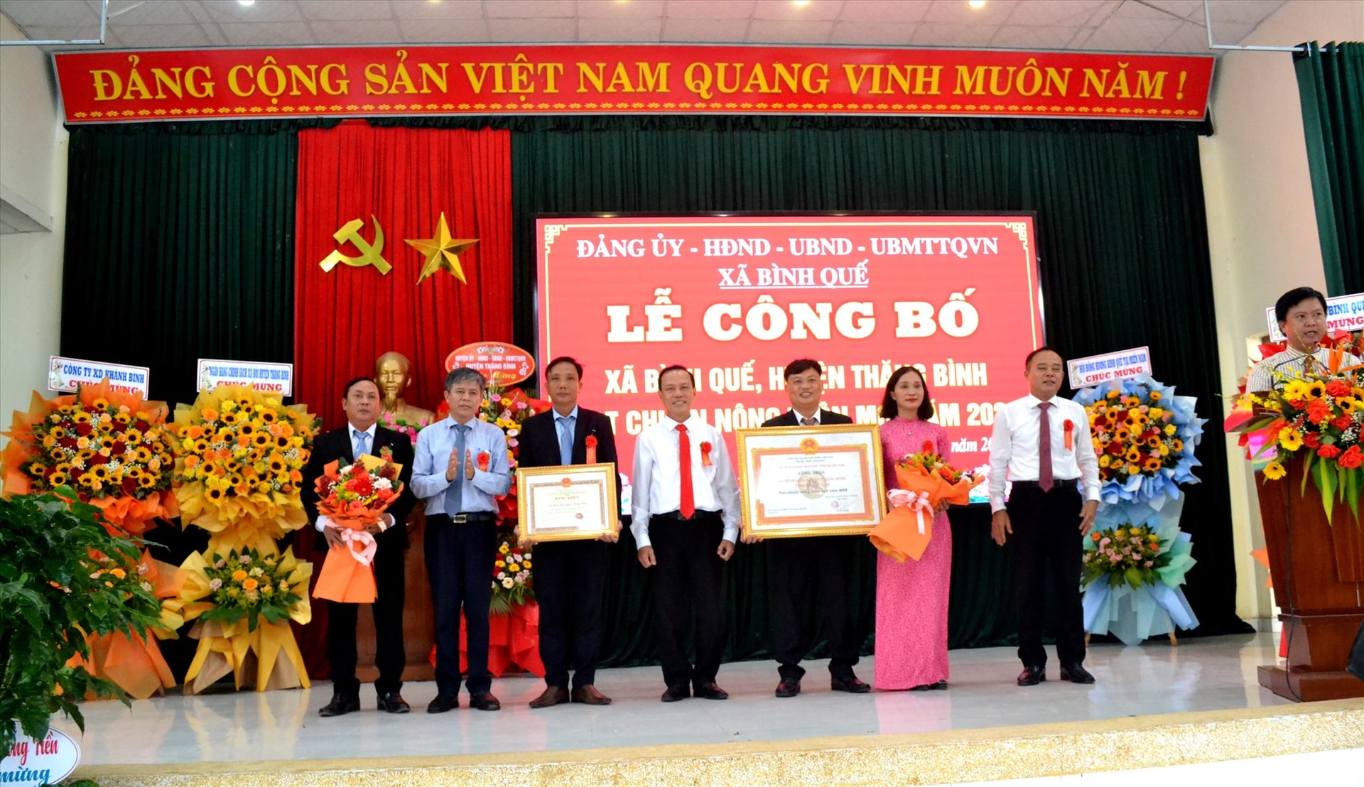 Ông Ngô Tấn - Phó Giám đốc Sở NN&PTNT trao bằng công nhận xã đạt chuẩn NTM năm 2022 của UBND tỉnh cho lãnh đạo xã Bình Quế. Ảnh: Q.VIỆT