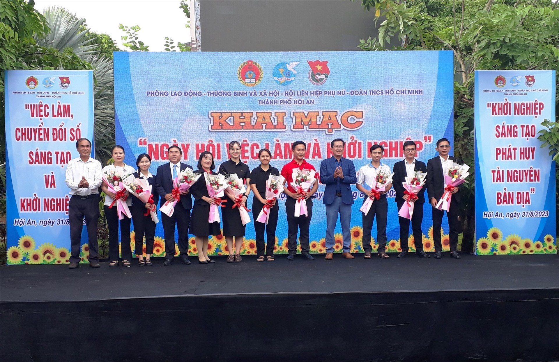 Phó Chủ tịch UBND thành phố Nguyễn Văn Lanh và lãnh đạo Phòng LĐ-TB&XH thành phố tặng hoa cho đại diện 12 doanh nghiệp và cơ sở đào tạo, tuyển dụng lao động tham gia Ngày hội.