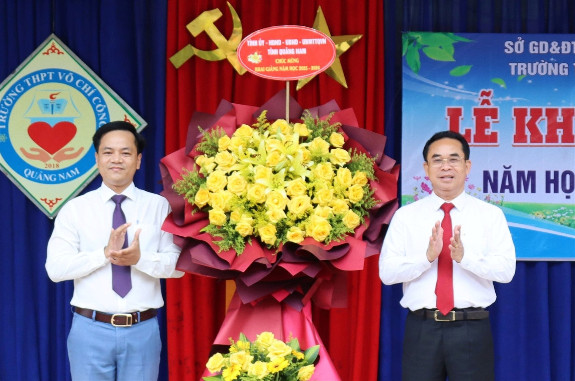 Đại diện lãnh đạo Trường THPT Võ Chí Công đón nhận lẵng hoa chúc mừng từ Phó Chủ tịch UBND tỉnh Trần Anh Tuấn. Ảnh: Đ.N
