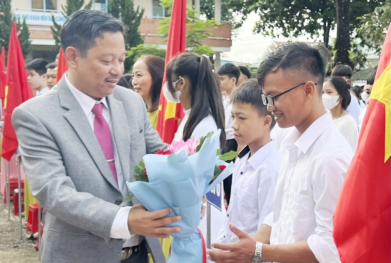 Thầy giáo Trương Công Thứ - Hiệu trưởng Trường THPT Khâm Đức (Phước Sơn) tặng hoa giáo viên chủ nhiệm và học sinh khối lớp 10. Ảnh: Y.D