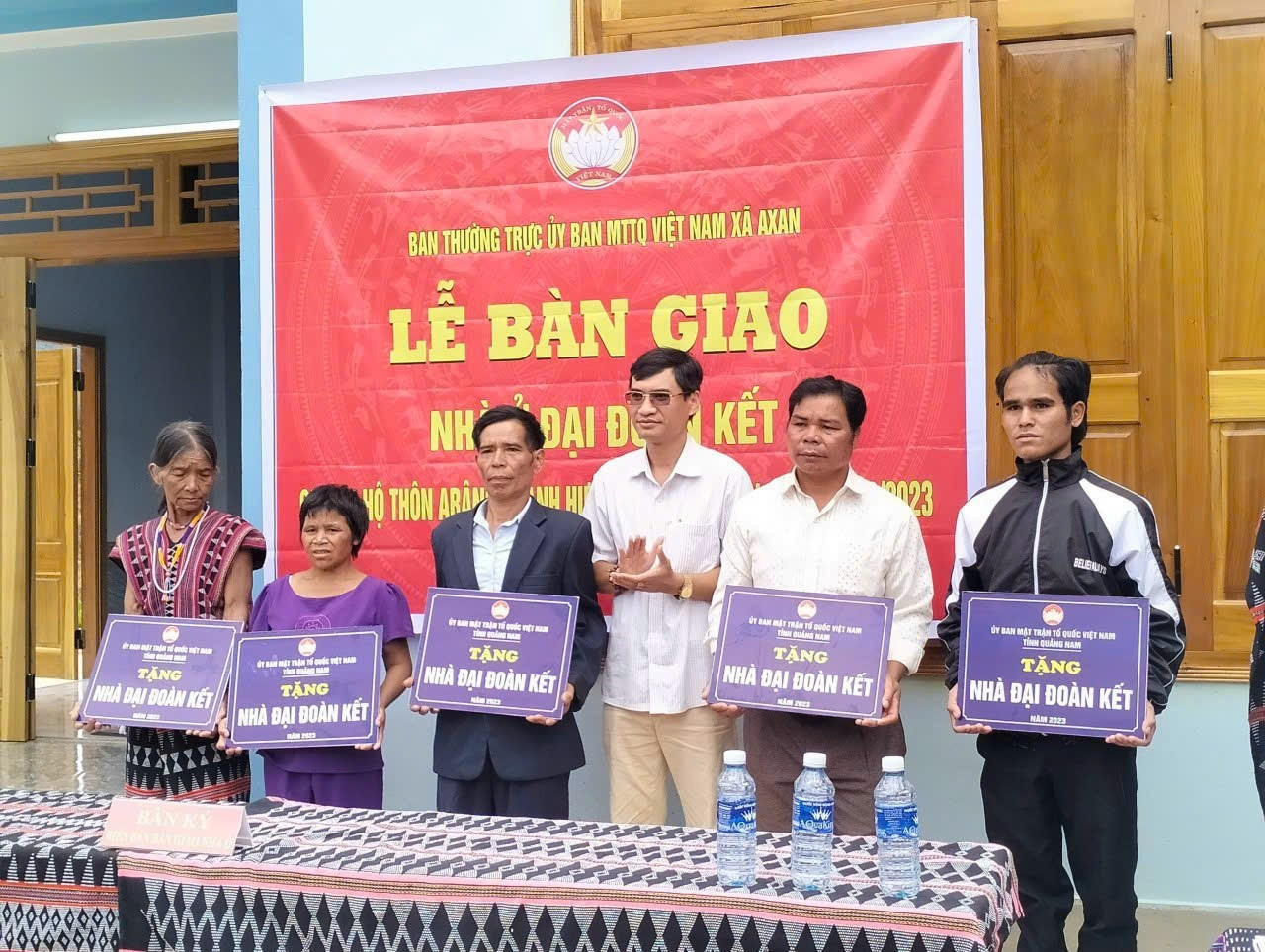 Ông Briu Quân - Chủ tịch Ủy ban MTTQ Việt Nam huyện Tây Giang (thứ 3, từ phải sang) trao bảng hiệu các ngôi nhà cho người dân. Ảnh: L.T
