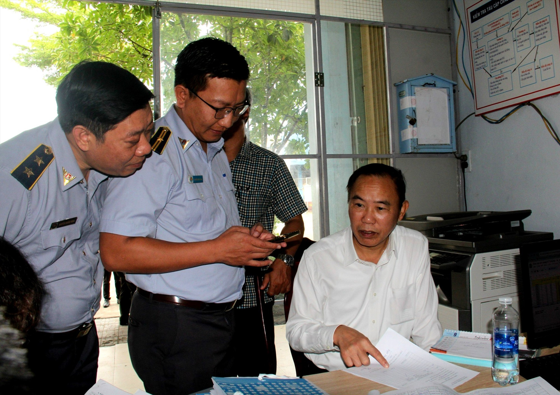 Thứ trưởng Bộ NN&PTNT Phùng Đức Tiến kiểm tra các hồ sơ, sổ sách về nghề cá Quảng Nam. Ảnh: Q.VIỆT