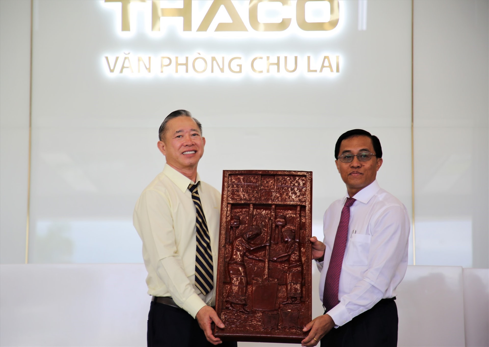 A representative of THACO (left) gives Sekong leader a gift.