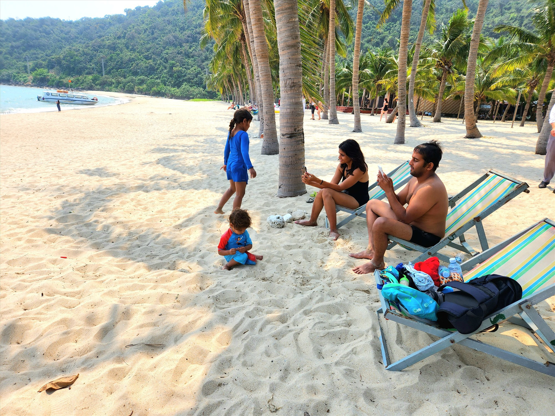 Du khách quốc tế thư giãn bên bãi biển ở Cù Lao Chàm. Ảnh: Q.T
