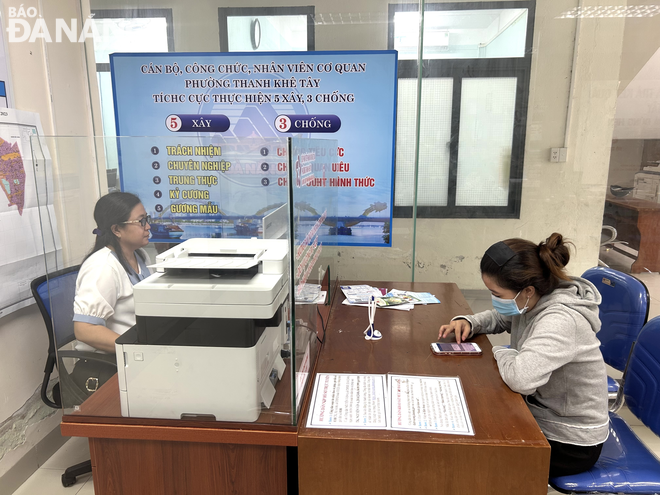 UBND quận Thanh Khê xếp hạng 1 nhóm UBND các quận, huyện. Trong ảnh: Công chức bộ phận một cửa UBND phường Thanh Khê Tây (quận Thanh Khê) hỗ trợ người dân đăng ký tài khoản định danh điện tử. Ảnh: M.Q