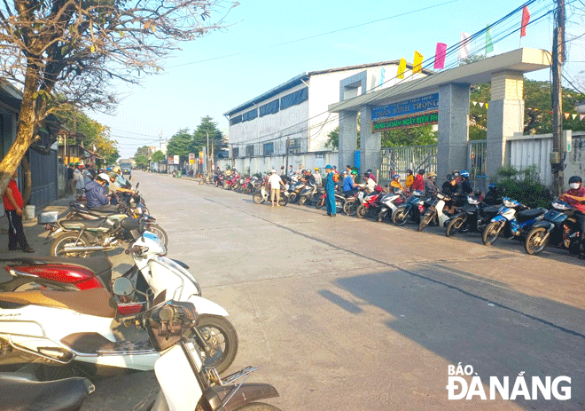 Các phụ huynh trong quá trình chờ đón con trước Trường Tiểu học Trần Bình Trọng (phường Hòa Hiệp Bắc, quận Liên Chiểu) chấp hành việc đậu đỗ xe đúng quy định, góp phần bảo đảm an toàn giao thông trước cổng trường. Ảnh: V.H