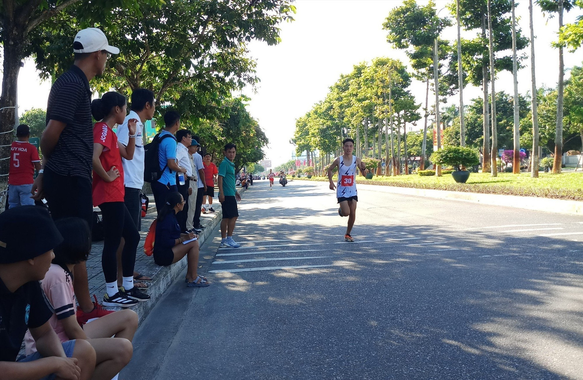 Các cổ động viên và người dân xem các vận động viên thi đấu ngay bên đường chạy. Ảnh: NGUYỄN TUẤN