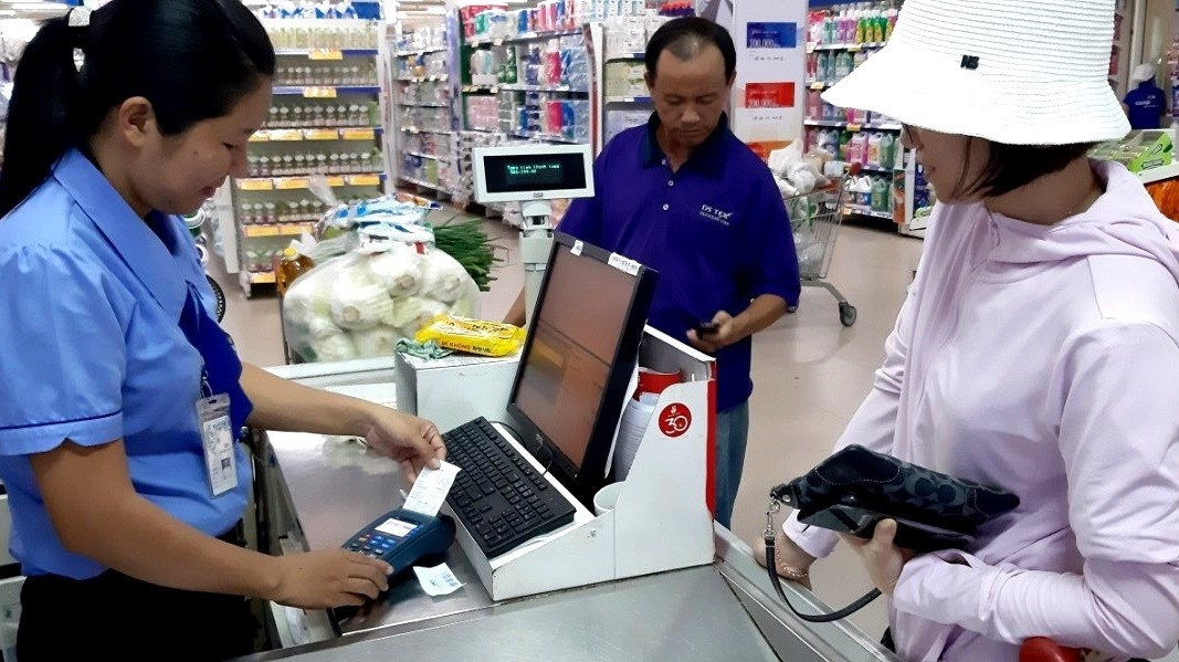 Người tiêu dùng thanh toán không dùng tiền mặt ở siêu thị Co.opMart Tam Kỳ. Ảnh: NGUYỄN QUANG
