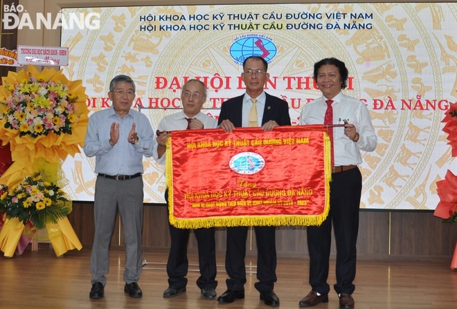 Lãnh đạo Hội Khoa học kỹ thuật cầu đường Việt Nam (trái) tăng cờ đơn vị hoạt động tiêu biểu về khoa học và công nghệ nhiệm kỳ 2018-2023 cho Hội Khoa học kỹ thuật cầu đường Đà Nẵng tại đại hội. Ảnh: HOÀNG HIỆP