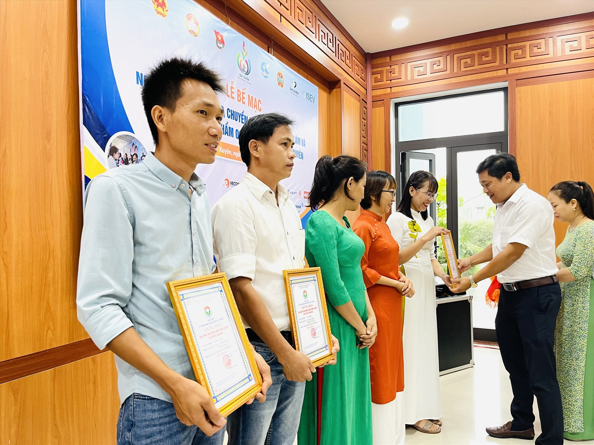 Lãnh đạo huyện Duy Xuyên trao giải Nhất cho sản phẩm thanh gạo lứt hạt và rong biển của HTX Nông nghiệp xanh Duy Oanh. Ảnh: N.P