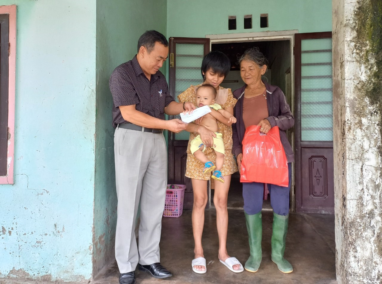 Lãnh đạo huyện Quế Sơn tặng quà cho trẻ có hoàn cảnh đặc biệt khó khăn ở xã Quế Minh. Ảnh: Duy Thái