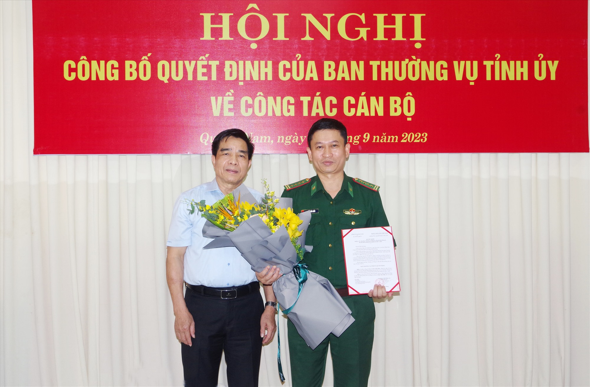 Phó Bí thư Tỉnh ủy Lê Văn Dũng đã trao quyết định và tặng hoa cho Đại tá Trần Tiến Hiền. Ảnh: HỒNG ANH