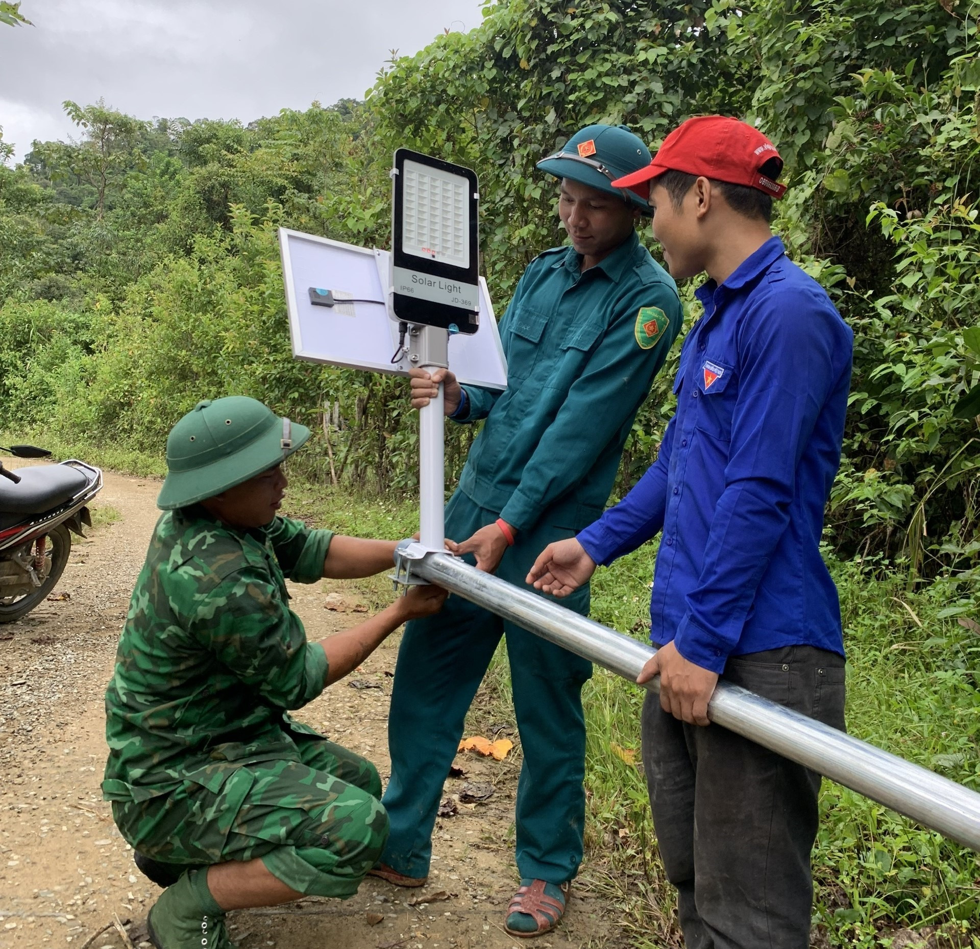 Cán bộ, chiến sĩ biên phòng cùng đơn vị thiện nguyện lắp đặt đèn năng lượng mặt trời cho thôn biên giới xã Chơ Chun. Ảnh: MINH NHƠN