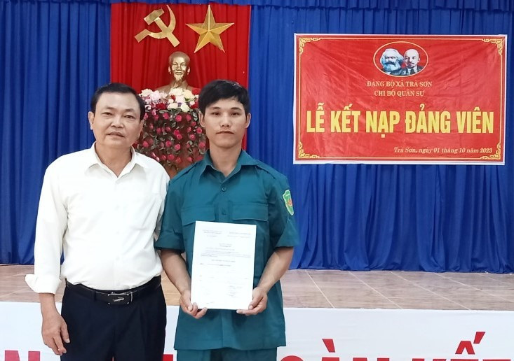Ông Lê Doãn Phước, Bí thư Đảng uỷ xã Trà Sơn chúc mừng và trao quyết định kết nạp đảng viên mới cho đồng chí Đinh Văn Linh.
