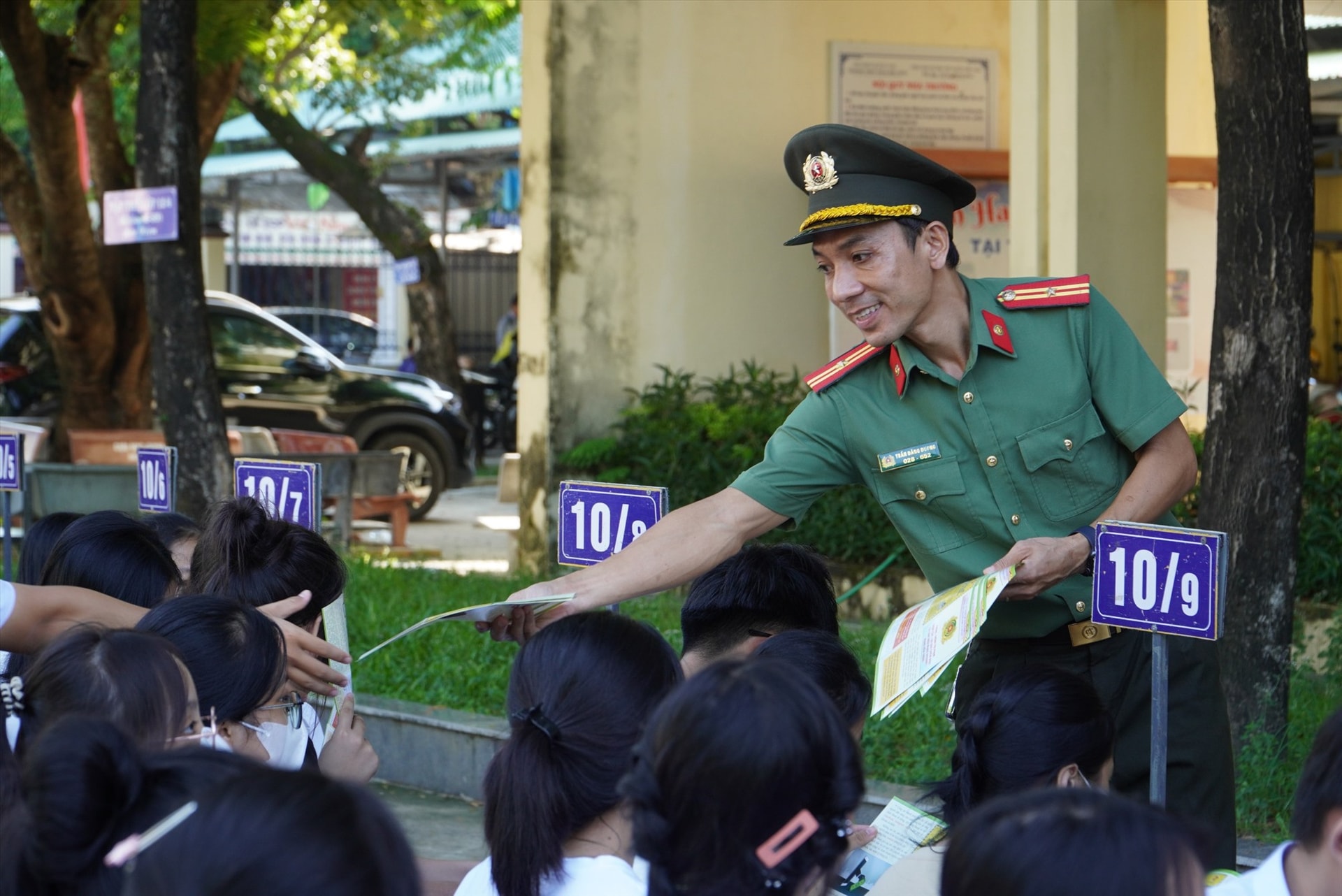 Phát tờ rơi tuyên truyền phòng chống lừa đảo qua internet, mạng xã hội cho các em học sinh. Ảnh: HỒ QUÂN