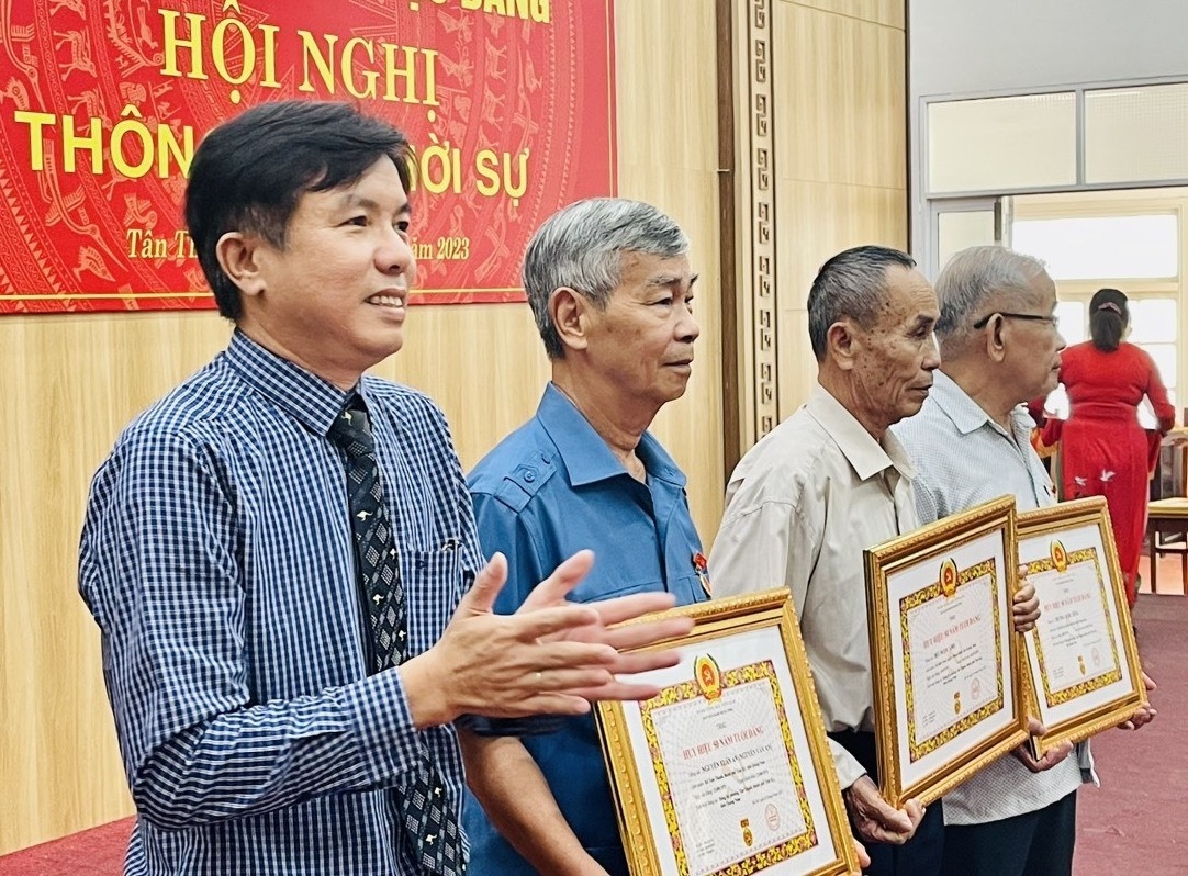 Đồng chí Đỗ Văn Minh - Bí thư Đảng ủy trao Huy hiệu đảng cho các Đảng viên.
