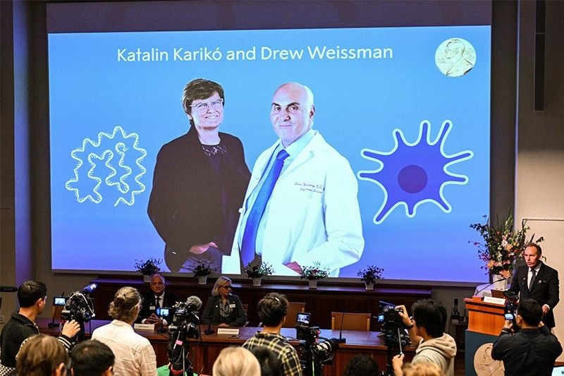 Chủ nhân giải Nobel Y học 2023 - Giáo sư Katalin Karikó (trái) và Drew Weissman xuất hiện trên màn hình trong lễ công bố của Ủy ban Nobel. Ảnh: AFP