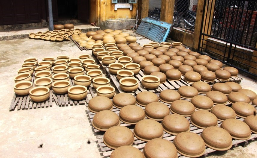 Clay pots are dried in the sun before …