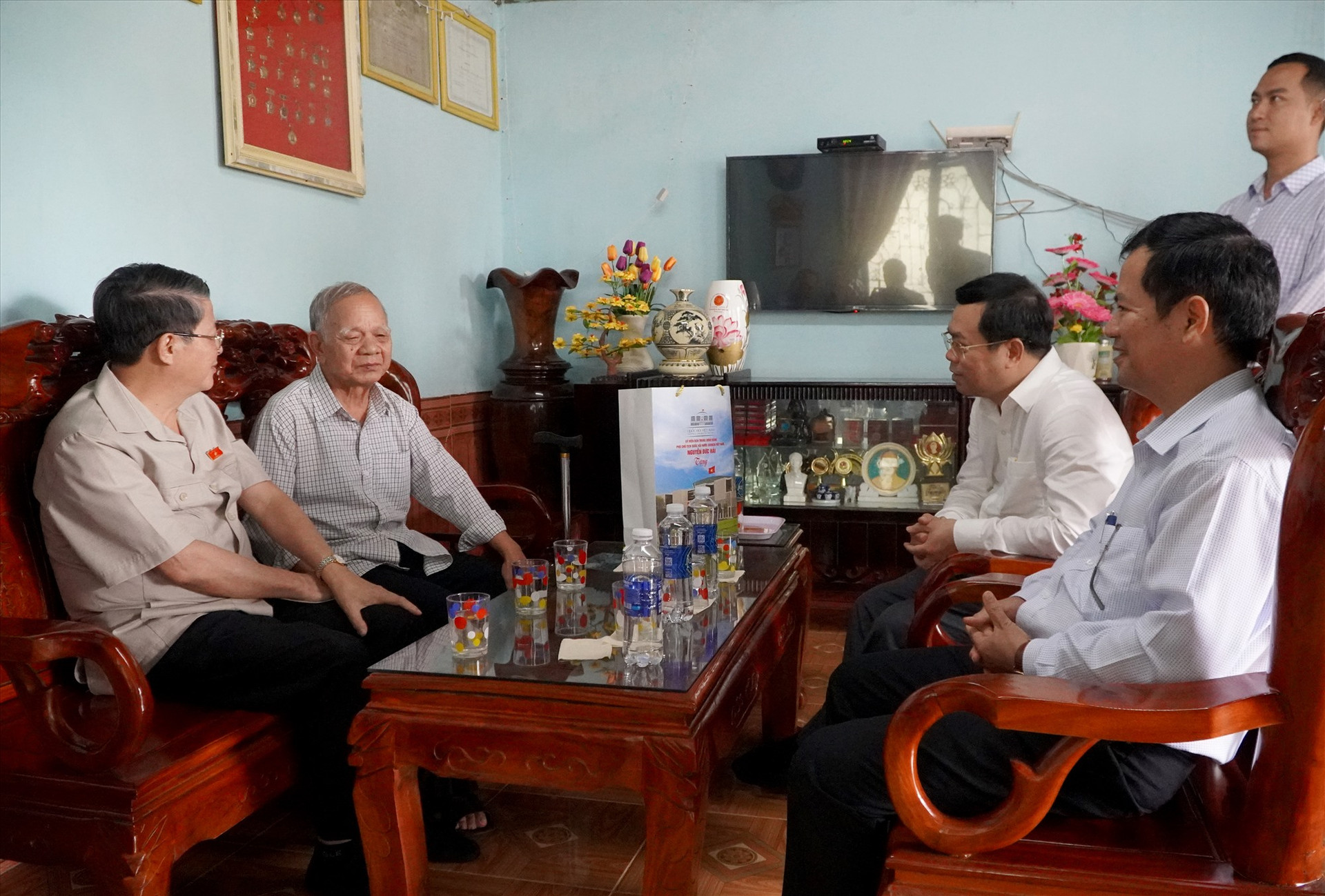 Phó Chủ tịch Quốc hội Nguyễn Đức Hải cùng đại biểu Quốc hội, lãnh đạo huyện Phước Sơn thăm hỏi già Hồ Văn Điều. Ảnh: C.Q