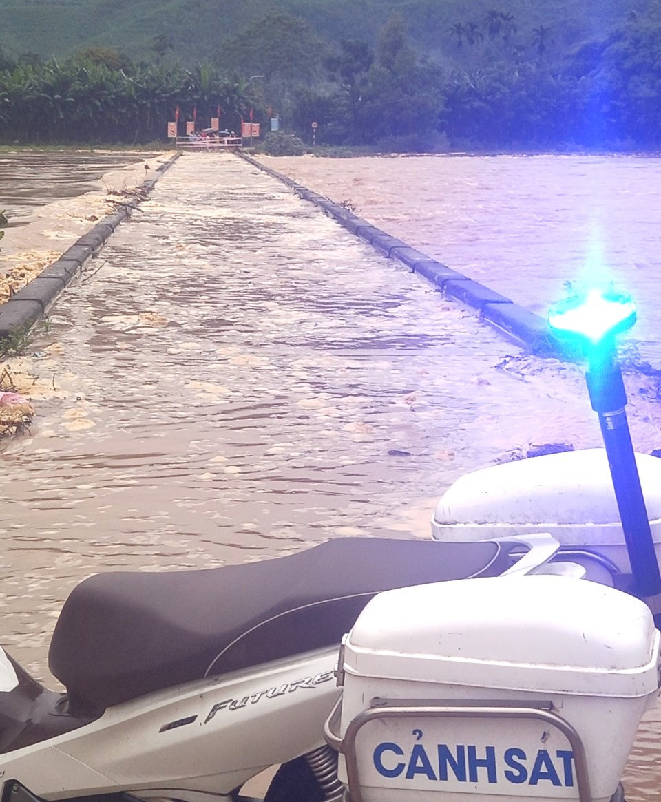 Lực lượng chức năng xã Đại Hưng chốt chặn khu vực cầu trên tuyến ĐH13.ĐL qua thôn Thái Chấn Sơn bị ngập. Ảnh: T.C.T