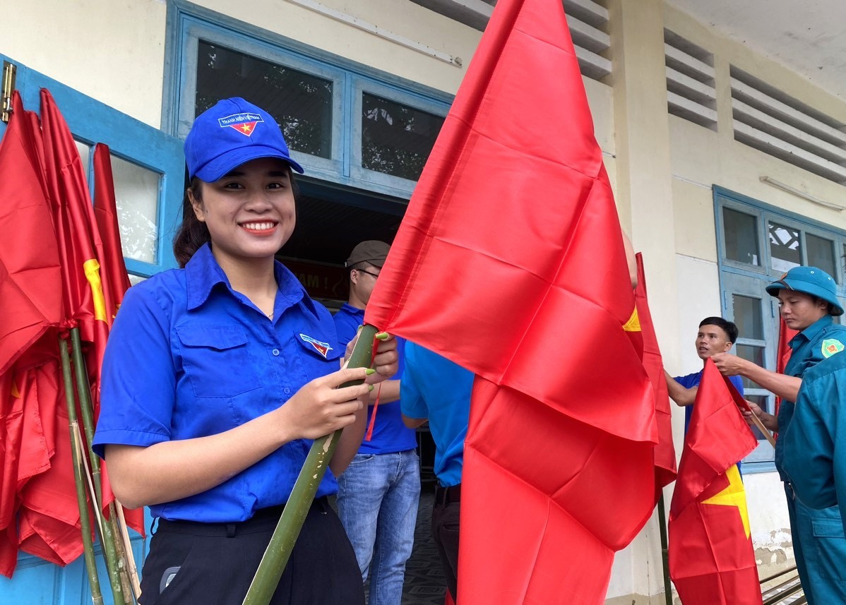 Một nữ cán bộ đoàn tham gia hoạt động cắm cờ Tổ quốc tại các khu dân cư. Ảnh: Đ.N