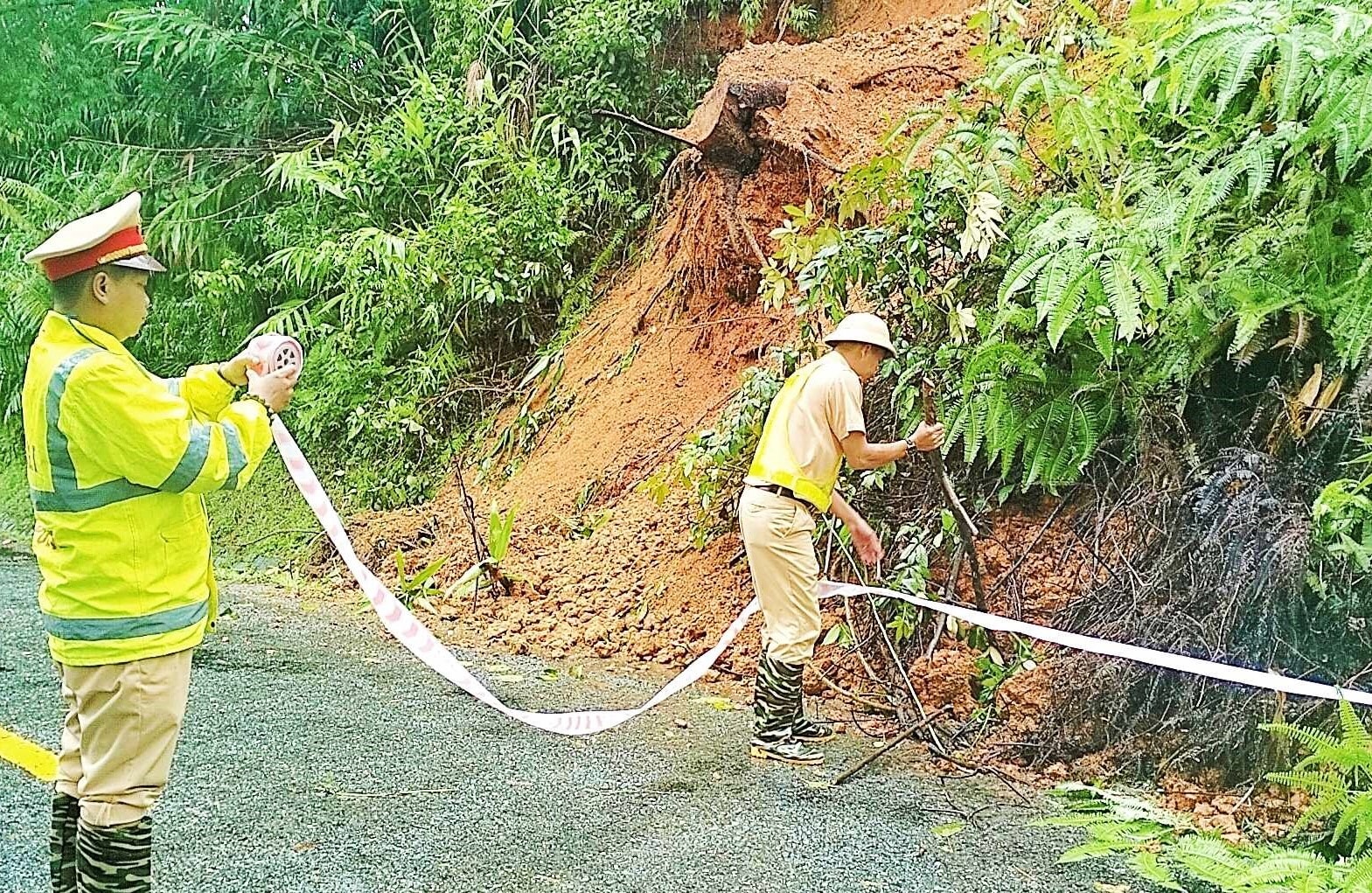 Lực lượng CSGT huyện Đông Giang giăng dây cảnh báo nguy hiểm tại các điểm sạt lở. Ảnh: Đ.N