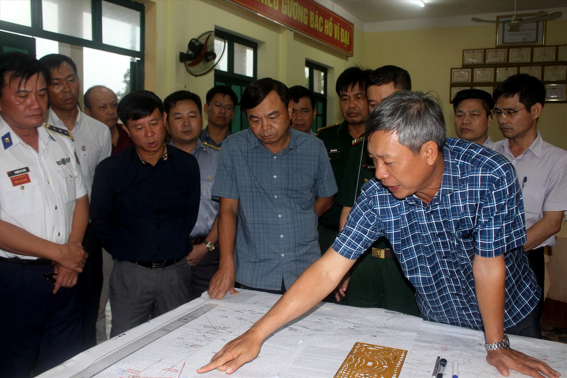 Phó Chủ tịch UBND tỉnh Hồ Quang Bửu báo cáo với Thứ trưởng Nguyễn Hoàng Hiệp (áo ngắn tay, đứng giữa) công tác ứng cứu, vào chiều 17/10. Ảnh: TC