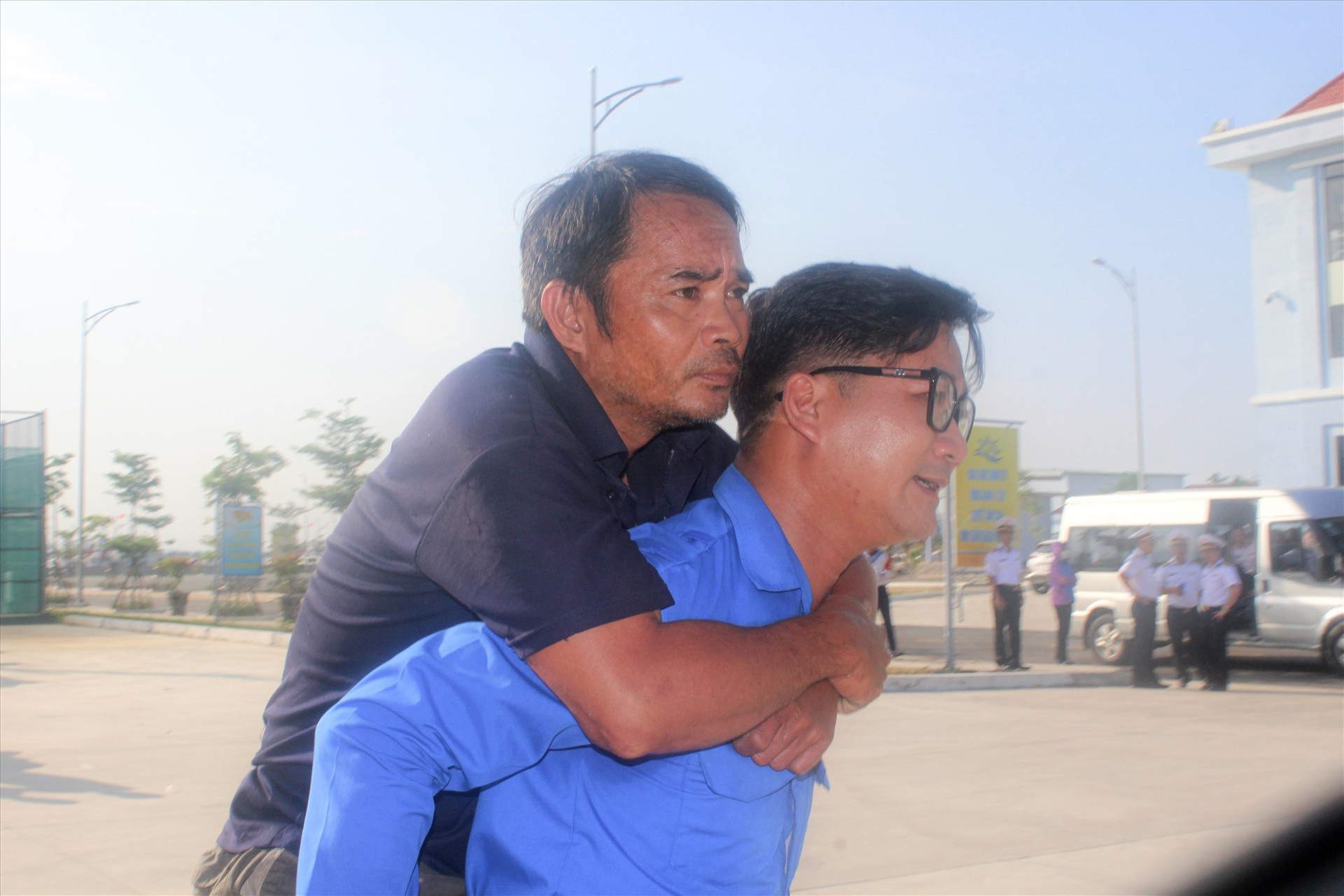 Ngư dân Nguyễn Hữu Đối được cõng lên xe. Ông Đối bị thương ở chân sau vụ tai nạn chìm tàu. Ảnh: C.Q