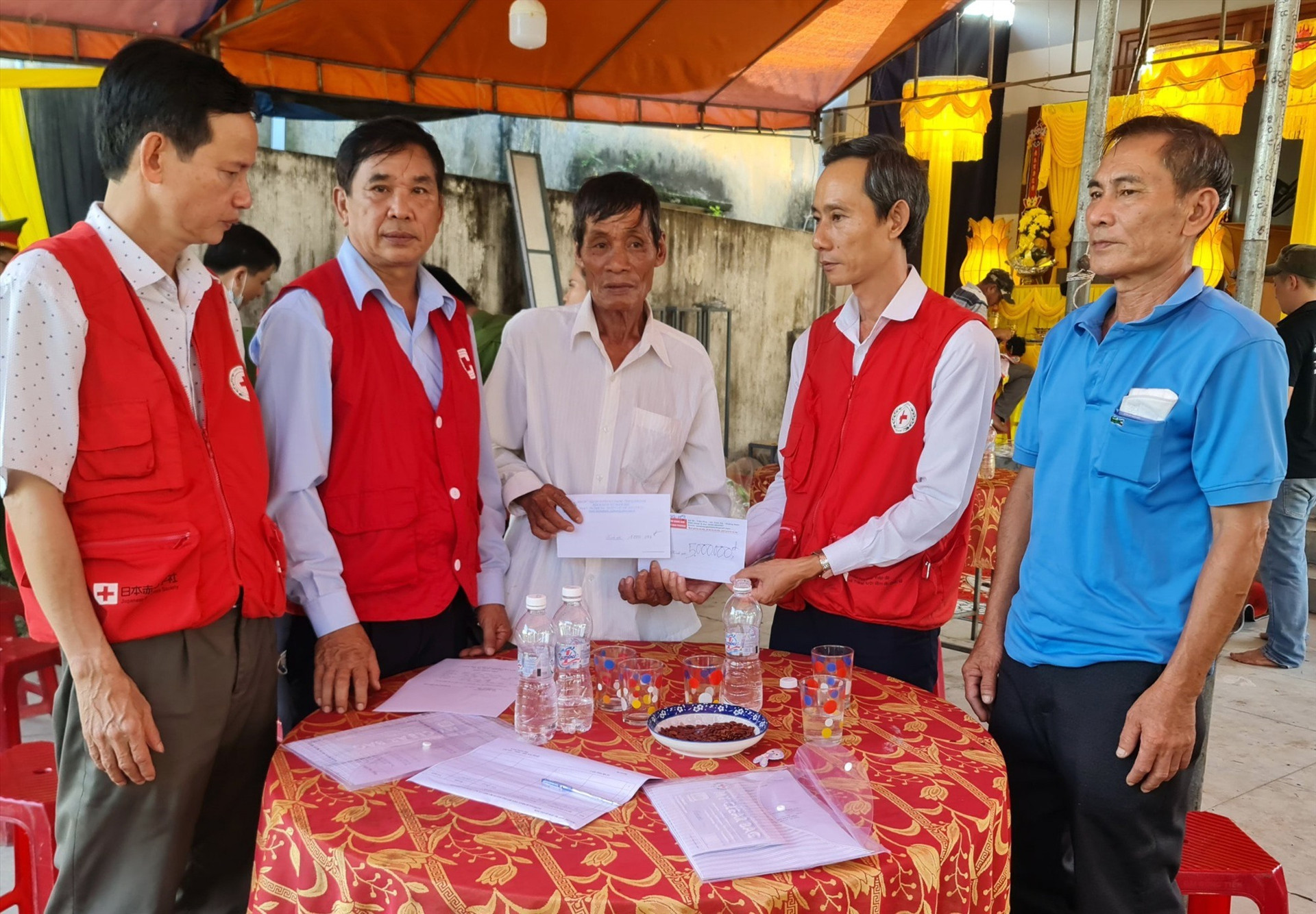 Đại diện Hội Chữ thập đỏ tỉnh và huyện Núi Thành trao tiền hỗ trợ, động viên gia đình có ngư dân bị tử nạn đã đưa về lo mai táng.