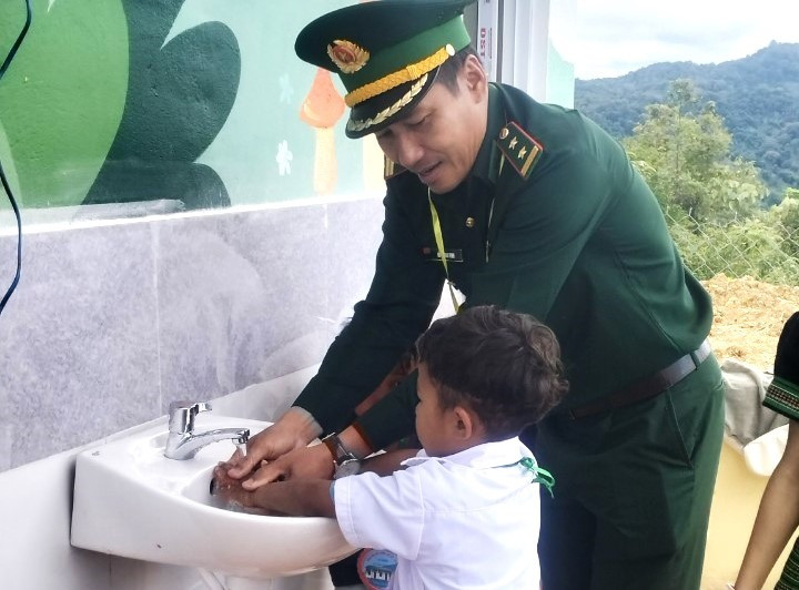 Chiến sĩ biên phòng hướng dẫn học sinh cách rửa tay hợp vệ sinh. Ảnh: Đ.N