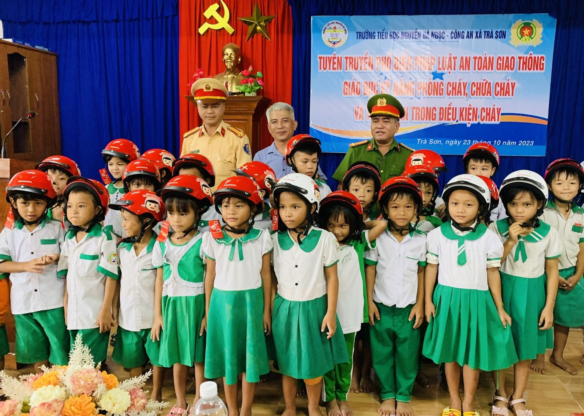 Trao tặng mũ bảo hiểm cho học sinh trường Tiểu học Nguyễn Bá Ngọc (Trà Sơn). ẢNH TÚ VÂN