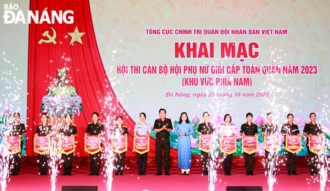 Trung tướng Nguyễn Văn Gấu, Ủy viên Trung ương Đảng, Phó Chủ nhiệm Tổng cục Chính trị (giữa) tặng cờ lưu niệm cho các đội tham gia hội thi. Ảnh: X.D