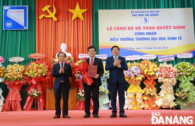 PGS.TS Nguyễn Ngọc Vũ, Giám đốc ĐH Đà Nẵng (bìa trái) trao quyết định cho PGS.TS Lê Văn Huy. Ảnh: NGỌC HÀ