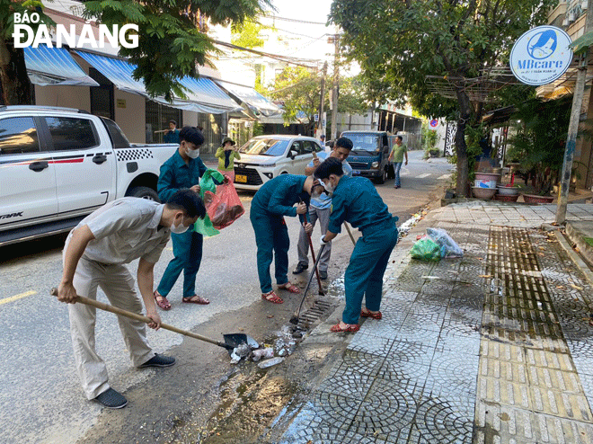 Các lực lượng của quận Thanh Khê ra quân khơi thông để thoát nước trên các tuyến đường ngày 22-10. Ảnh: HOÀNG HIỆP