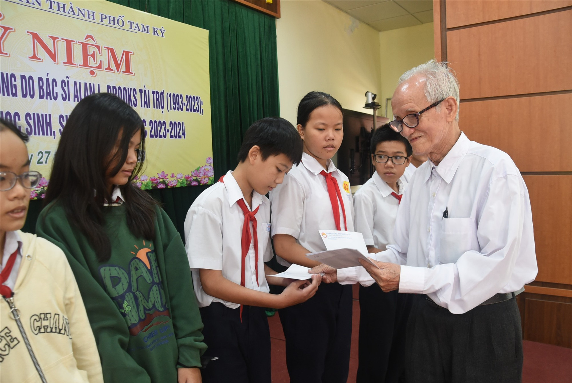 Ông Huỳnh Văn Luận trao học bổng cho học sinh. Ảnh: X.P