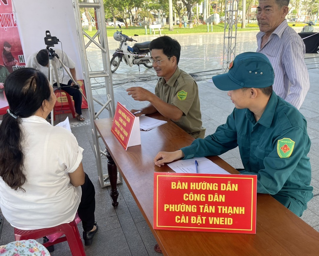 Dân quân phường Tân Thạnh tham gia hướng dẫn người dân cài đặt VneID tại ngày hội chuyển đổi số của TP.Tam Kỳ. Ảnh: Q.S
