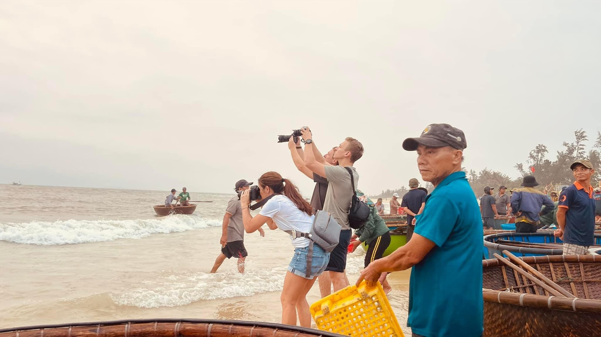 Du lịch trải nghiệm được xem là xu hướng mới hiện nay. TRONG ẢNH: Du khách quốc tế thích thú khi chứng kiến những chiếc thúng chai chở hải sản vào chợ cá Tam Tiến (Núi Thành). Ảnh: H.Q