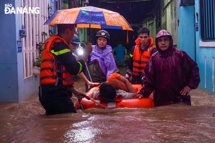 Lực lượng công an dùng phao cứu sinh đưa người dân tại khu vực đường Mẹ Suối (quận Liên Chiểu) đến nơi an toàn. Ảnh: C.A