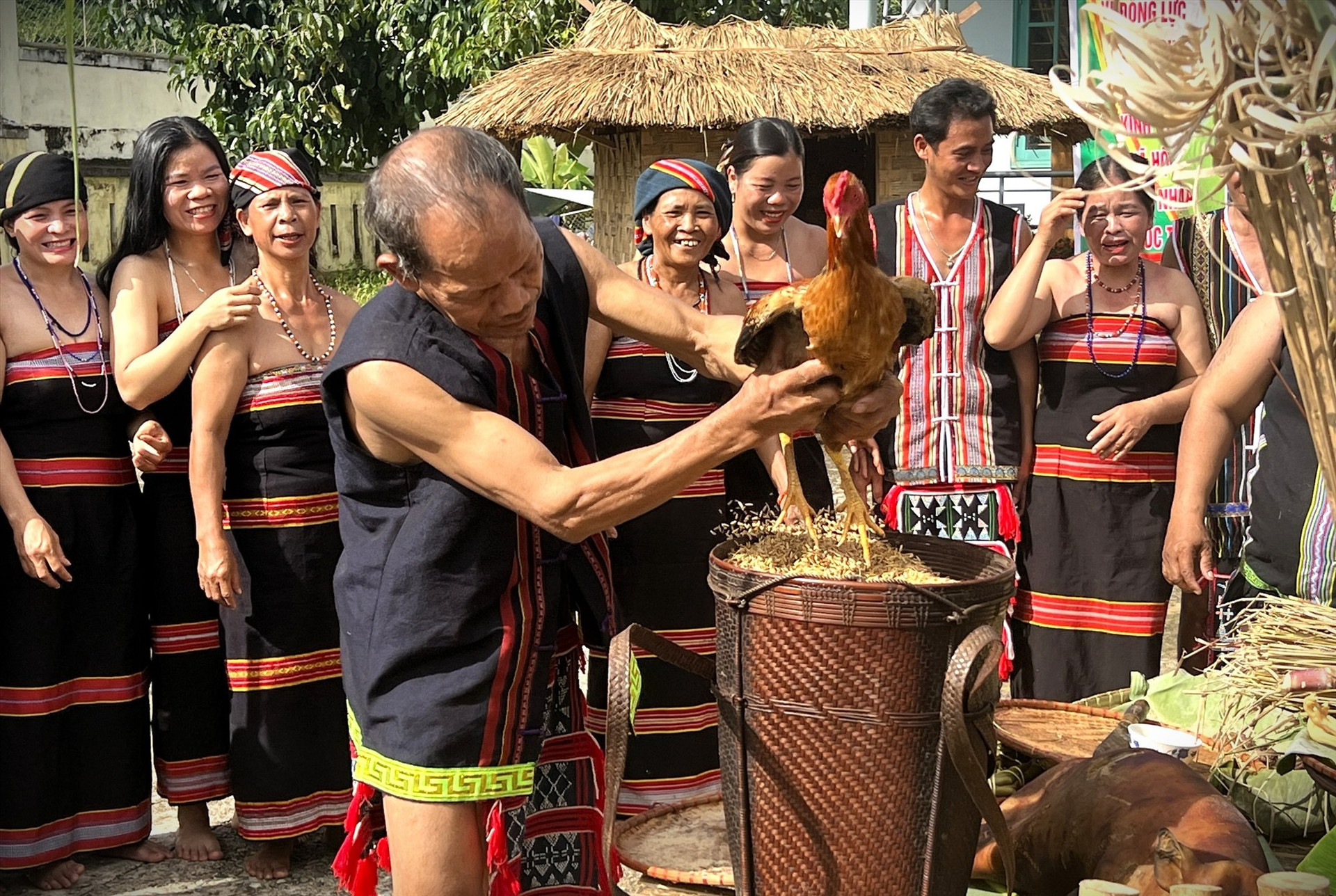 The village elder places a rooster on top of the rice offerings for blessings from the rice spirit.