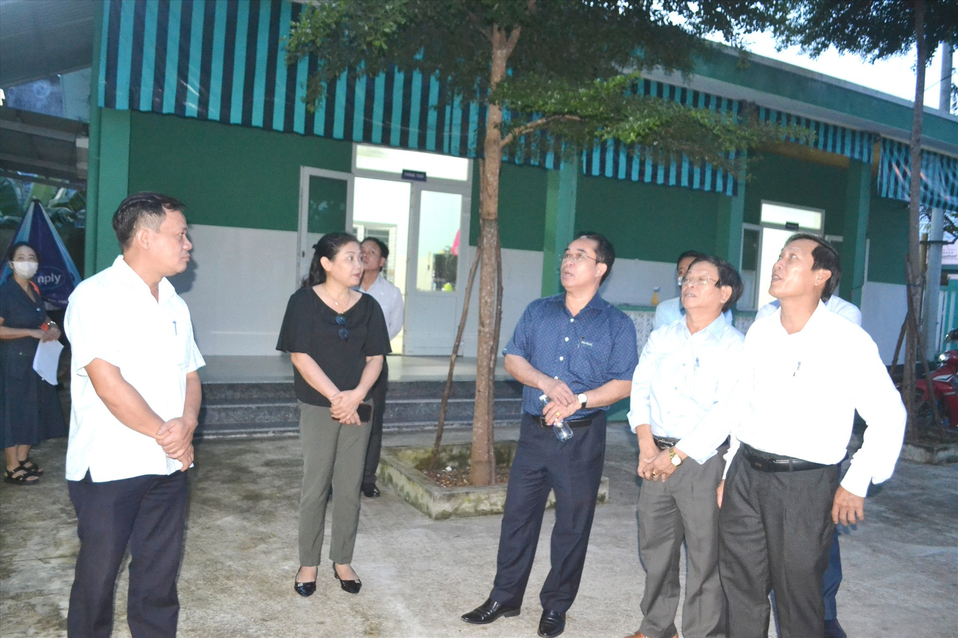 Đồng chí Trần Anh Tuấn (đứng thứ 3 từ phải sang) nghe địa phương báo cáo hiện trạng Trạm Y tế thị trấn Ái Nghĩa. Ảnh: C.T