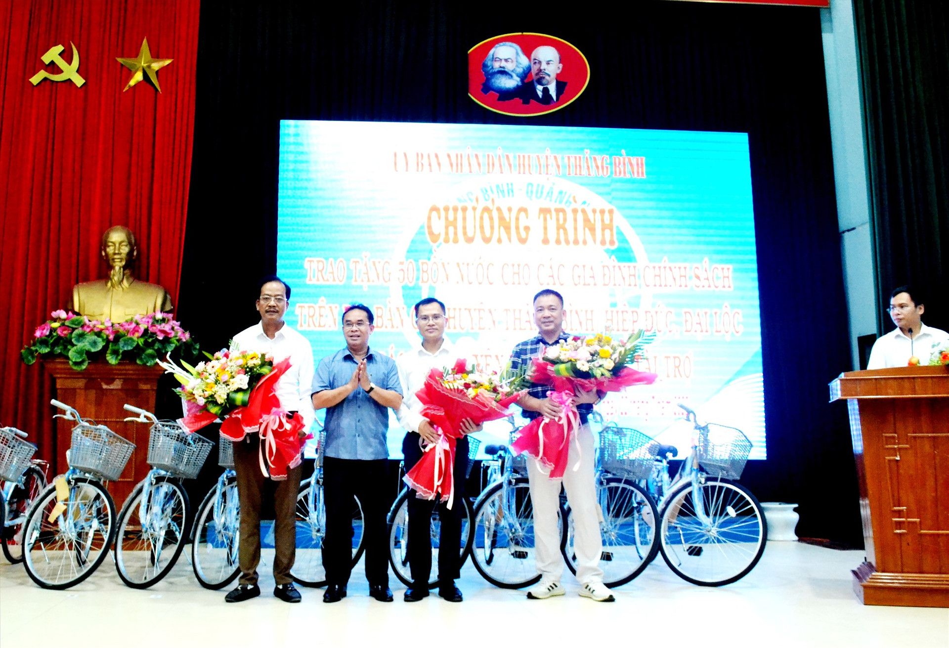 Phó Chủ tịch UBND tỉnh Trần Anh Tuấn tặng hoa các doanh nghiệp thực hiện an sinh xã hội trên địa bàn huyện Thăng Bình. Ảnh: Q.VIỆT