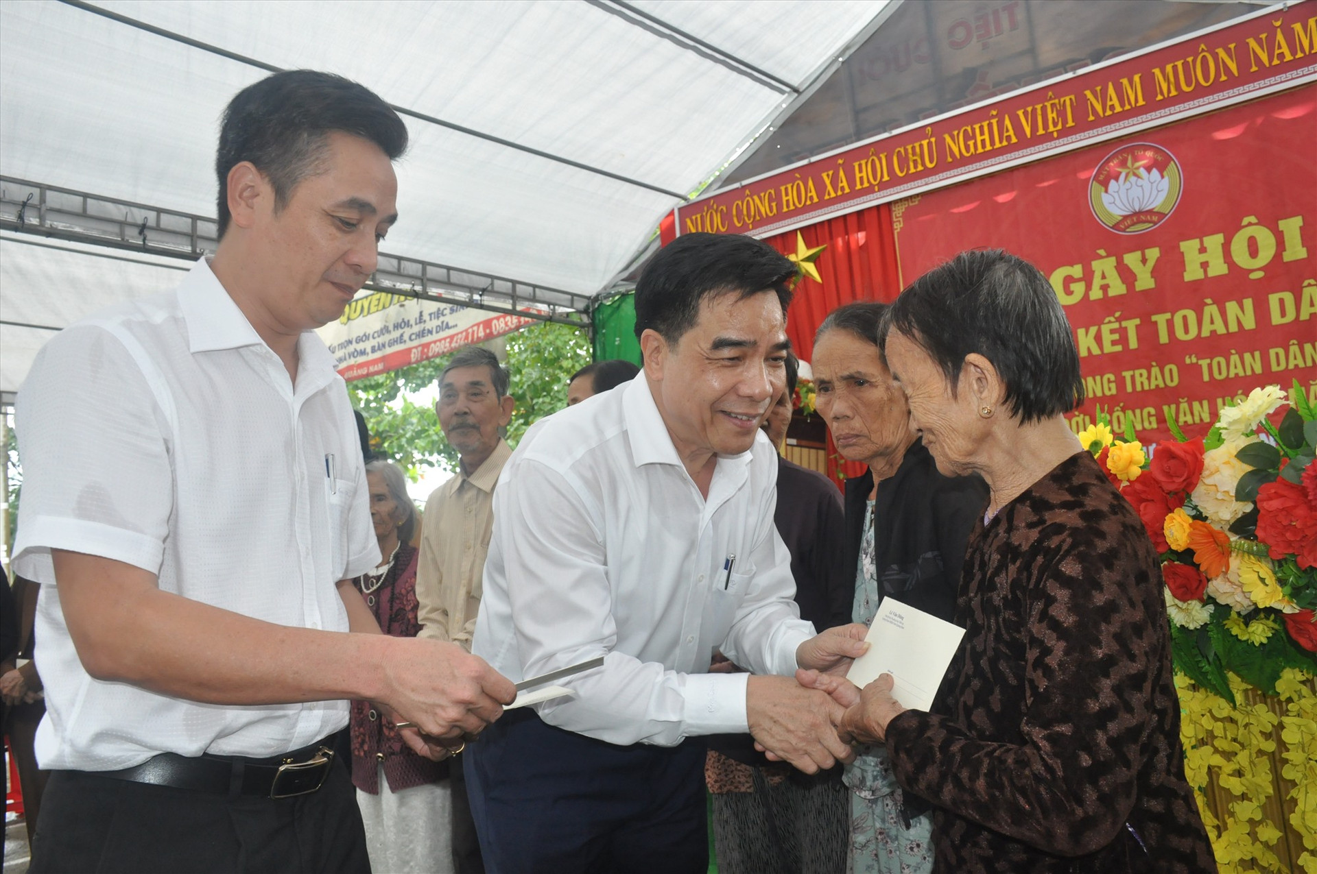 Đồng chí Lê Văn Dũng tặng quà cho các hộ gia đình khó khăn, chính sách của thị trấn Hương An. Ảnh: N.Đ