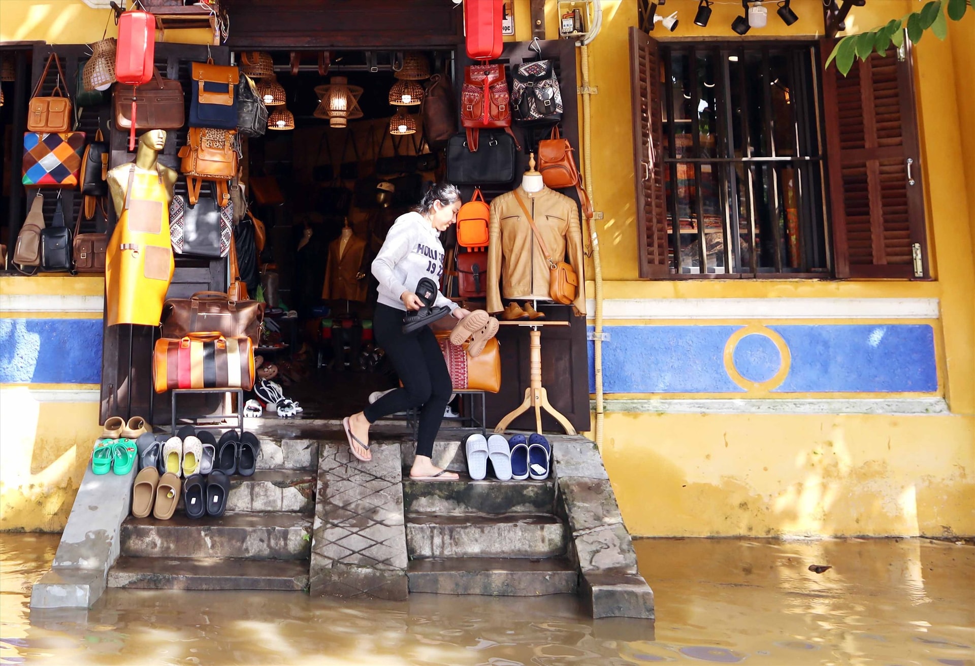 Một chủ của hàng kinh doanh trên đường Bạch Đằng mở cửa ngay khi lũ vừa rút khỏi thềm nhà.