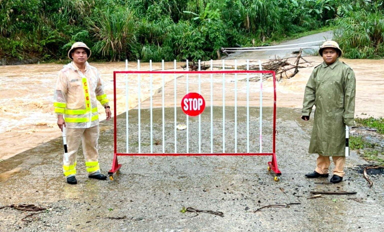 Công an huyện Tây Giang cắt cử lực lượng chốt chặn, rào chắn không cho lưu thông qua điểm nước lũ ngập sâu trên tuyến đường ĐH3.TG. Ảnh: C.T