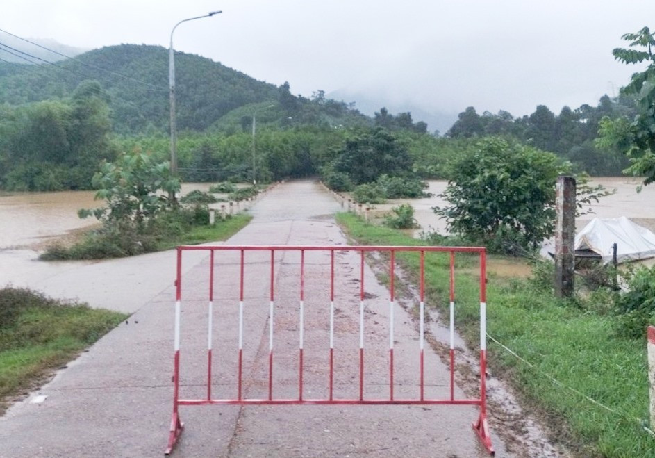 Nước lũ băng qua quốc lộ 14H, chia cắt lưu thông tại địa bàn xã Phước Ninh (huyện Nông Sơn). Ảnh: C.T