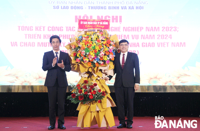 Phó Chủ tịch UBND thành phố Trần Chí Cường (bên trái) tặng hoa chúc mừng nhân ngày Nhà giáo Việt Nam. Ảnh: L.P