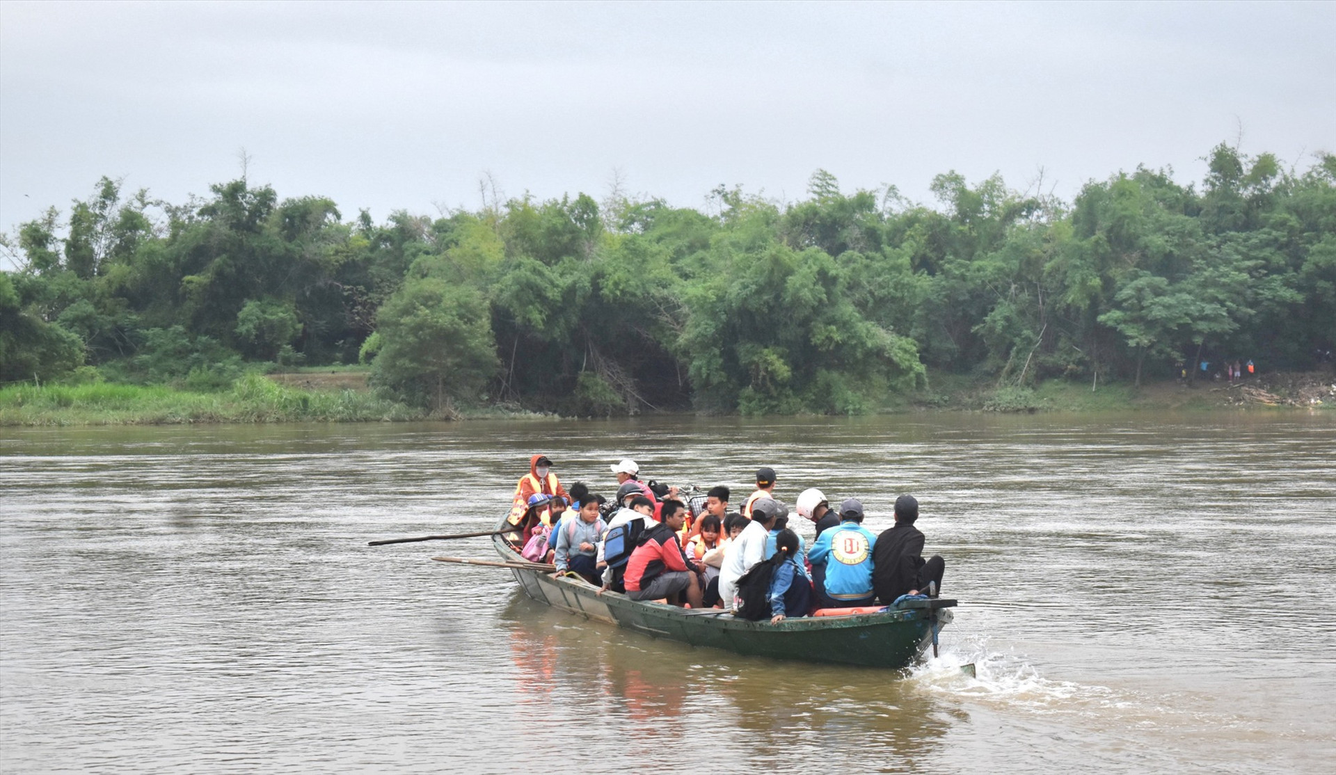 Người lái đò chở học sinh thôn Lệ Bắc qua sông giữa dòng nước chảy xiết. Ảnh: N.Q