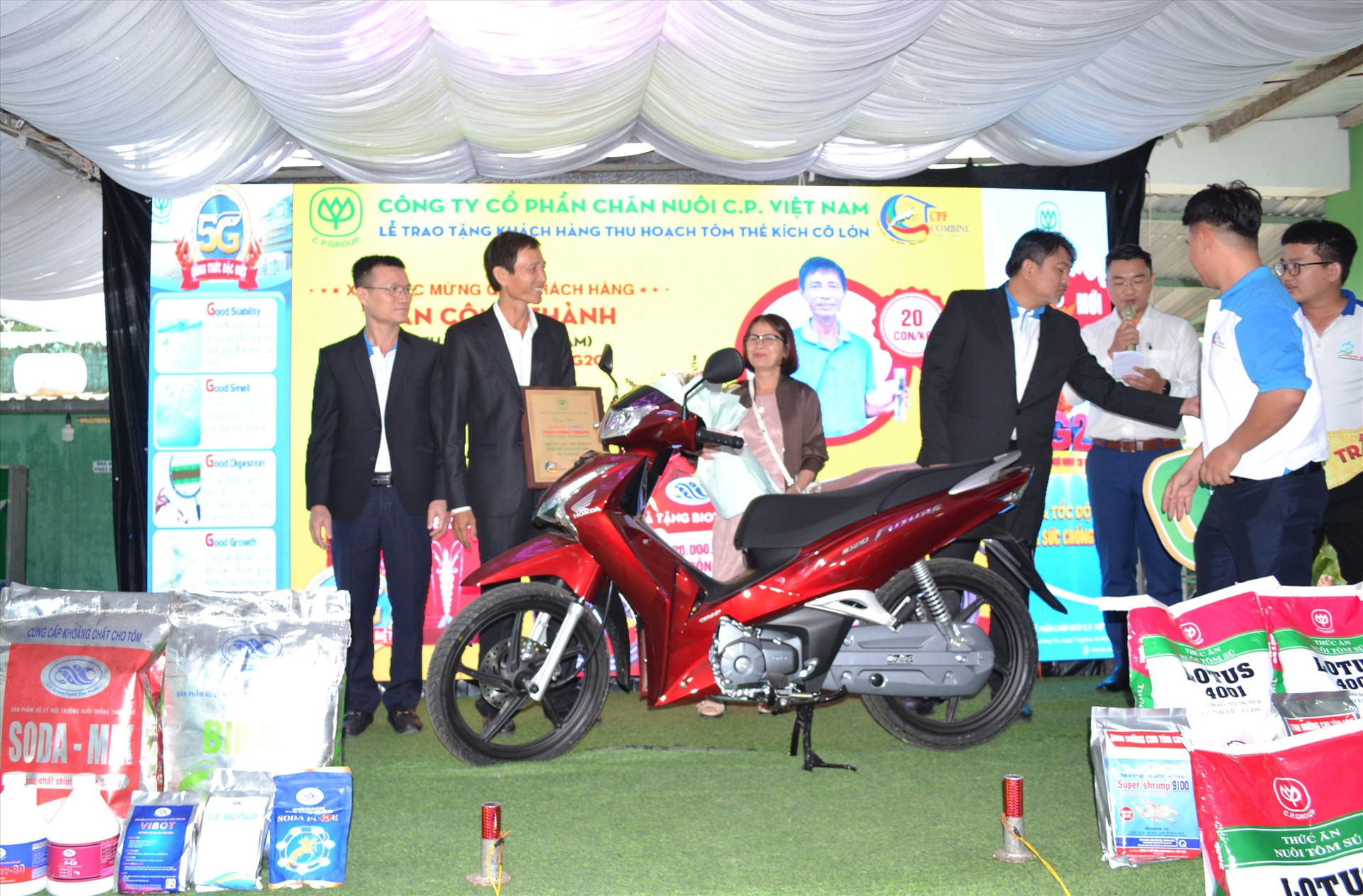 Ông Trần Công Thành (thứ 2 từ trái sang0 được Công ty CP Chăn nuôi C.P. Việt Nam thưởng xe máy Future nhờ nuôi tôm đạt cỡ 20 con/kg. Ảnh: Q.VIỆT